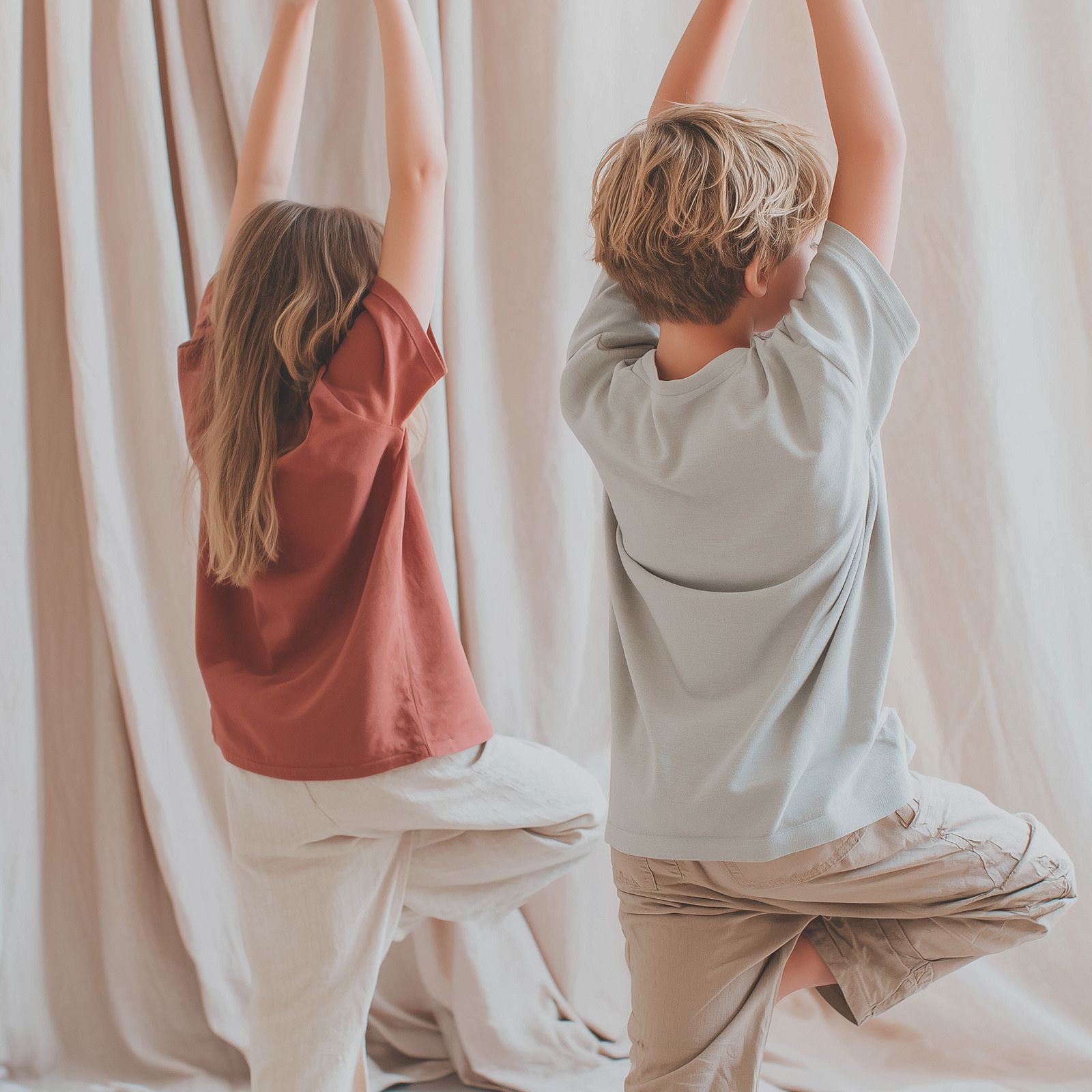 Zwei Kinder in der Baumhaltung im Yoga, von hinten fotografiert